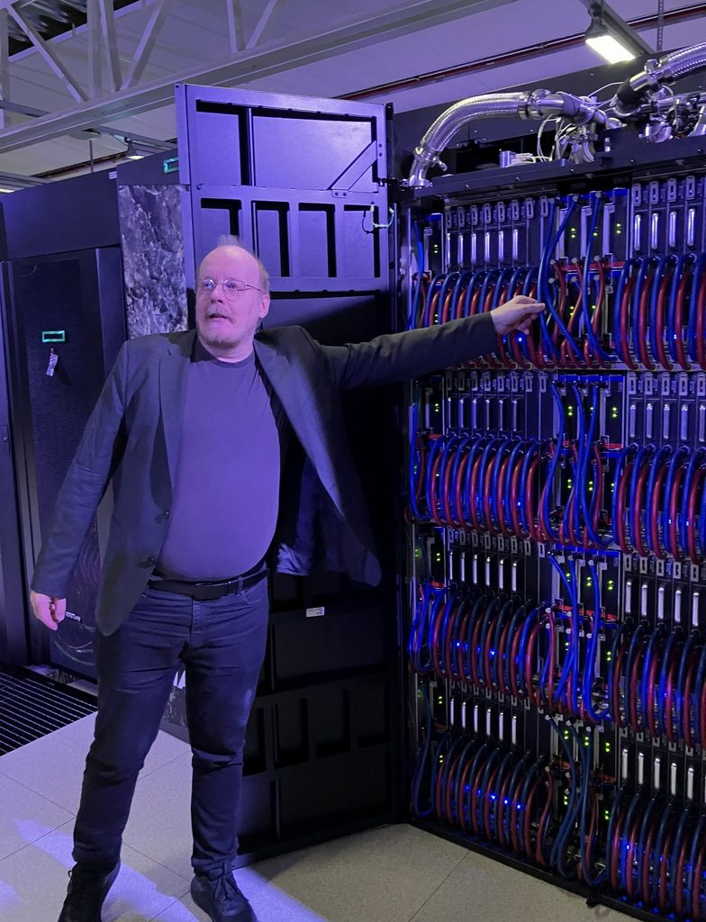 Peter Bortas visar den vattenkylda utrustningen i superdatorn ARRHENIUS, med synliga röda och blå kylslangar.