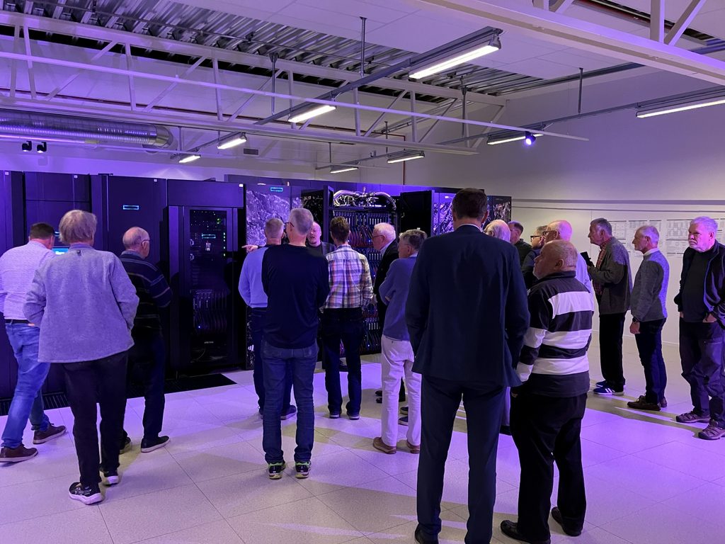 ÖTF:s deltagare samlade i datorhallen hos NAISS, omgivna av superdatorn ARRHENIUS stora datorskåp.